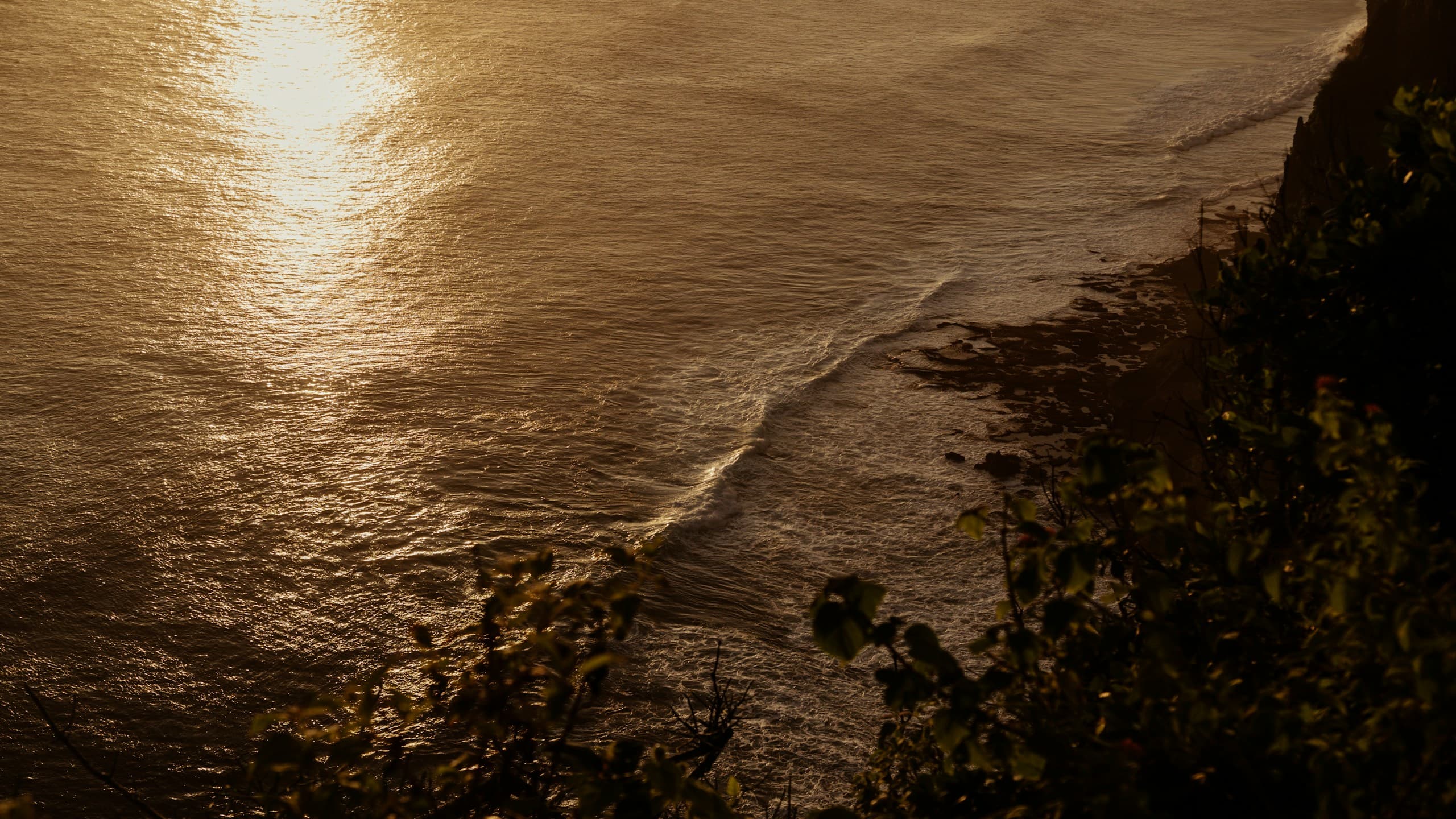 Waves meeting the shore at sunset in Bali